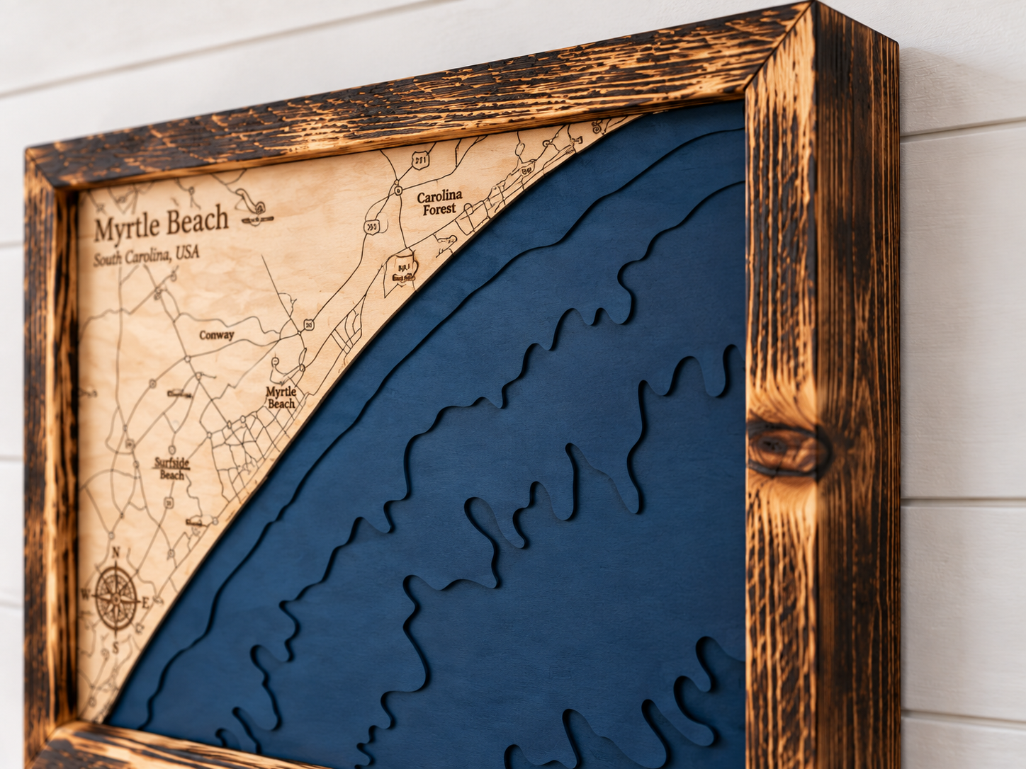 Close-up of the Myrtle Beach map's torched pine frame and layered navy ocean